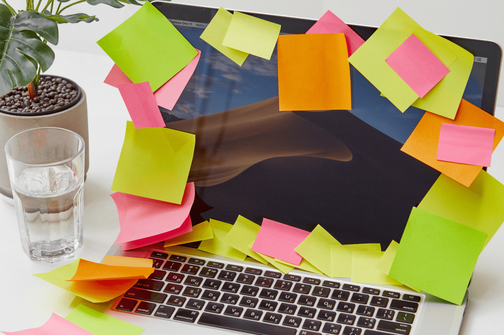 Laptop covered in colorful sticky notes — a playful symbol of organized chaos and mindful productivity for remote workers and digital nomads.
